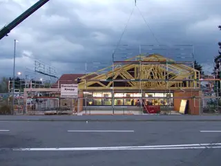 Gerüst am Neubau mit Holzdachstuhl an einer Straße