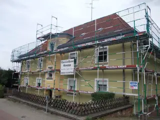 Fassadengerüst mit Seitenschutz an einem Wohnhaus mit gelber Fassade