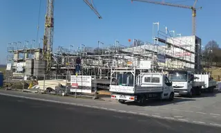 Gerüst-Lkw vor einem eingerüsteten Neubau