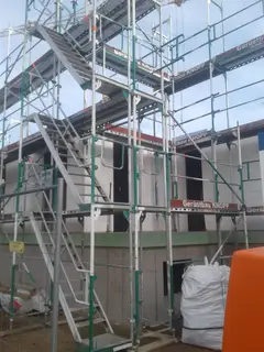Gerüst mit Treppenaufgang an einem mehrgeschossigen Neubau