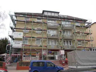 Fassadengerüst an einem Wohn- und Geschäftshaus mit Balkonen