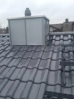 Mit Blech verkleideter Kamin auf einem Ziegeldach